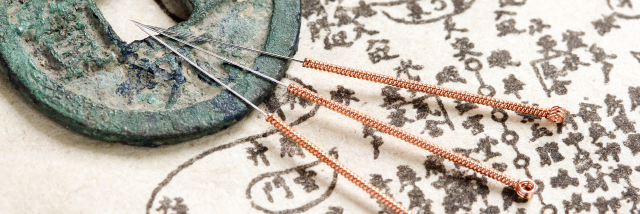 Ancient Chinese coin and acupuncture needles